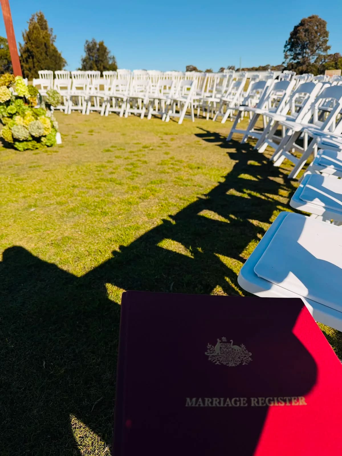 The marriage register open beside rows of chairs set for an outdoor ceremony
